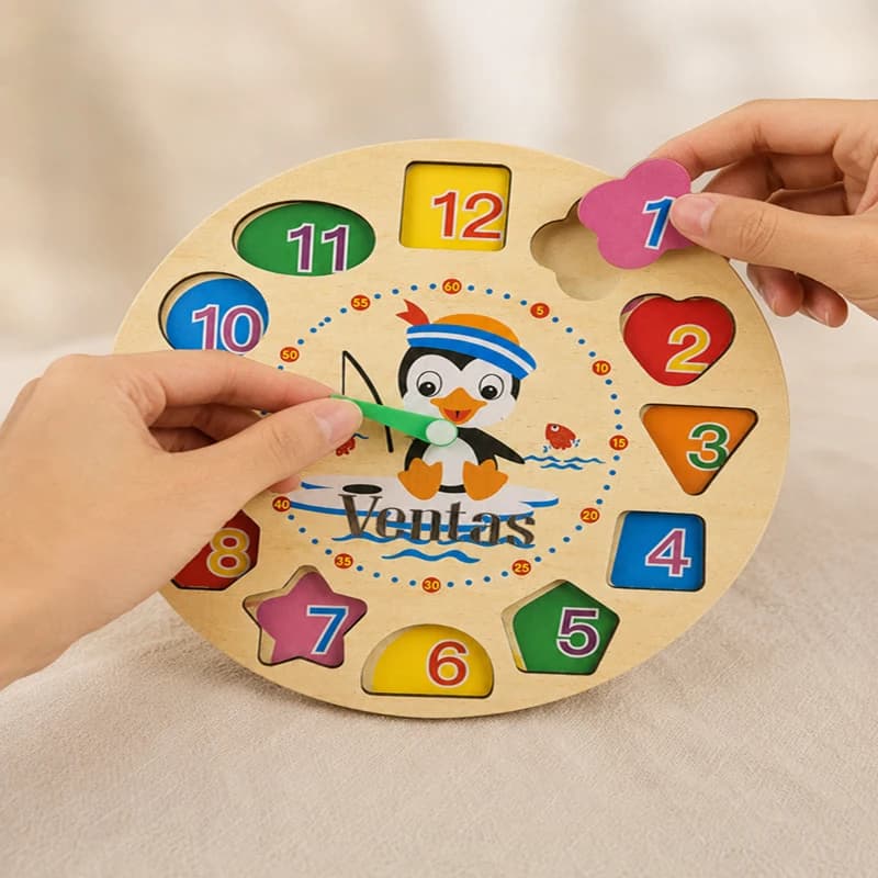 Hands placing number blocks on VENTAS penguin clock